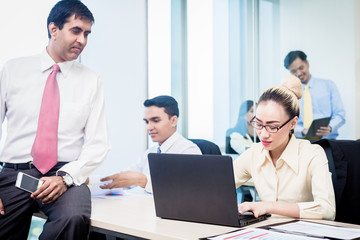 Obraz premium Asian business executive supervising his employees in office