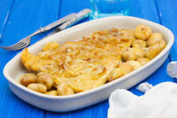 cod fish with chestnuts on dish on wooden background