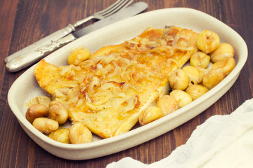 cod fish with chestnuts on dish on wooden background