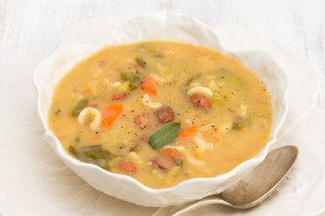 vegetable soup with beans, spinach and pasta in white bowl
