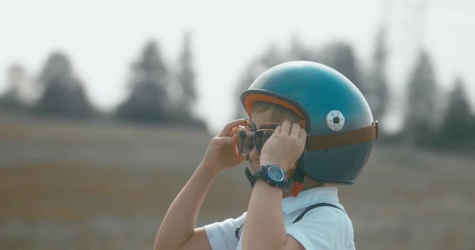 CU Little boy putting on vintage googles and helmet, pretending to be a pilot. 4K UHD RAW edited footage