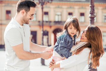 Young parents playing with their little daughter.