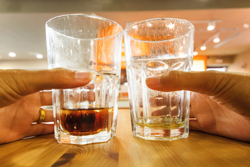 Hand holding a glass of  water on the table background.