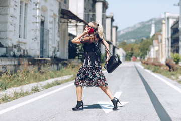 Young business woman with handbag running to catch the plane or train. Elegant trendy clothing. Hurrying to work concept.