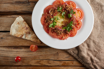 Fried dish of tomato, parsley, eggs and cheese inside.