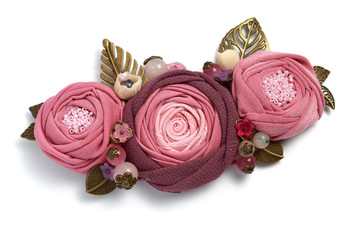 Handmade brooch in the form of three pink fabric flowers on a white background