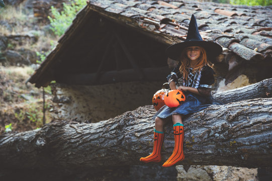 Cheerful kid in costume posing on trunk