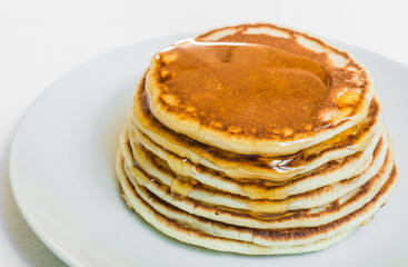 American pancakes with honey against white background