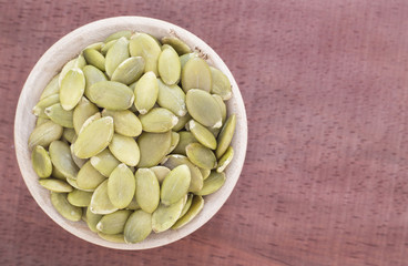 Pumpkin seeds on the wooden background
