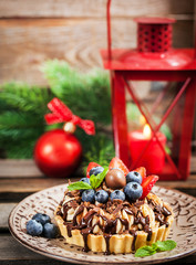 Banoffee chocolate pie decorated with chocolate, fresh blueberry and strawberry