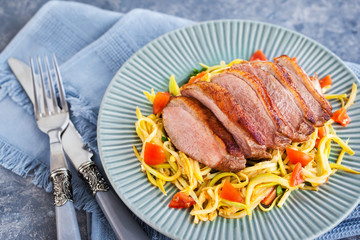 Roasted duck breast and zucchini noodles with tomatoes