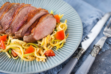 Roasted duck breast and zucchini noodles with tomatoes