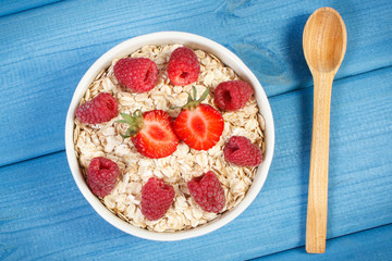 Fresh prepared oat flakes or oatmeal with strawberries and raspberries, healthy lifestyle and nutrition