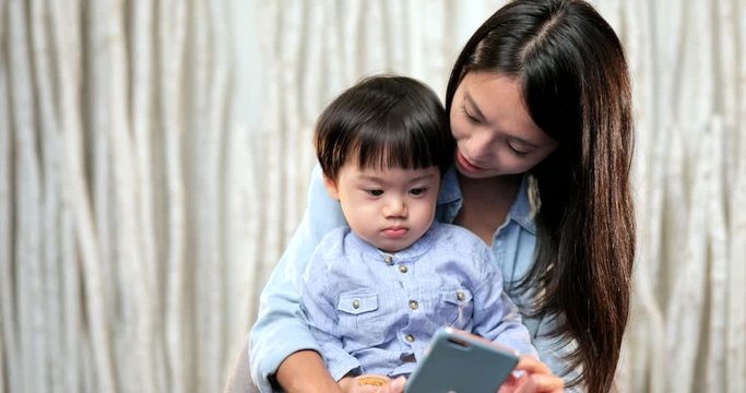 Mother watching cartoons on smartphone with her son
