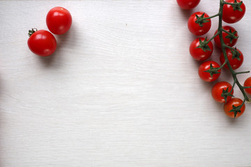 Naklejka na ściany i meble Bright red juicy tomatoes on white wooden background