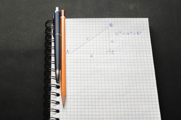 Page with formulas and the Pythagorean theorem with pen and pencil