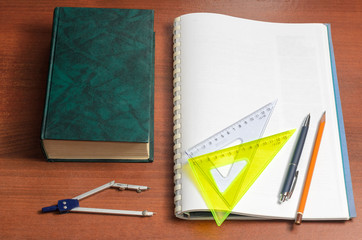 School accessories: pen, pencil, rulers, compasses, notebook and thick textbook