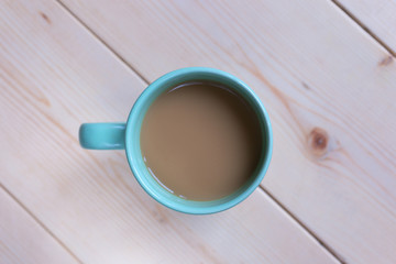Cup with coffee on wooden surface from above