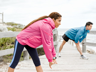 Young couple at the seaside doing exercises