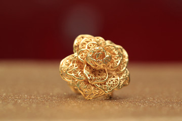 gold rose flower ring on glitter background