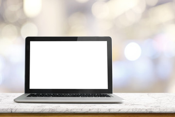 Mock up Blank screen of Laptop on white marble table in Co-working or cafe.