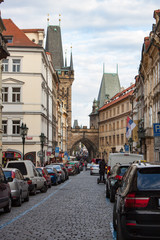 Fototapeta na wymiar Cobblestone Street in Prague With Cars on Both Sides