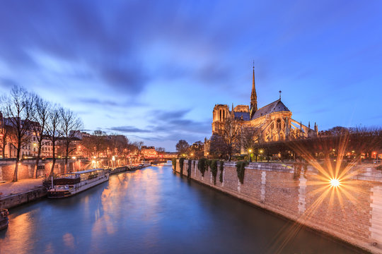 Notre dame in Paris (Our Lady of Paris) at twilight. It is a medieval Catholic cathedral, considered to be one of the finest examples of French Gothic architecture. View from the River Seine. France.