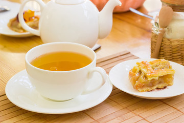 Herbal tea and a piece of cake on a saucer
