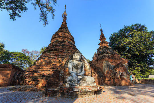 Buddha pagoda statue around area The brick yellow Maha Aung Mye Bon Zan Monastery well known as Me Nu Oak Kyaung or the Brick Monastery in Inwa (Ava) near Mandalay, Myanmar.