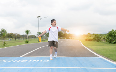 Happy asian fat boy running to the finished line.,