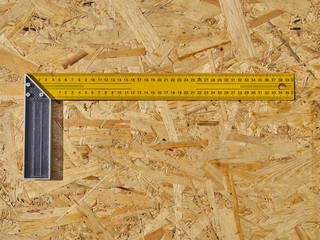 Fototapeta na wymiar Construction ruler on a wooden background