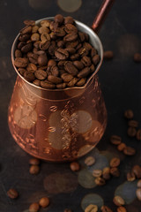 coffee beans in turk close-up on black background.