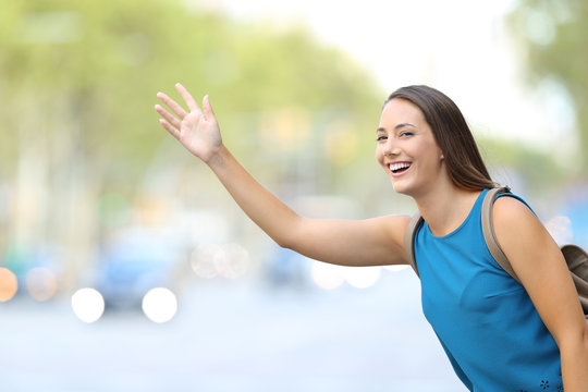 Happy Woman Hailing Taxi Cab On The Street