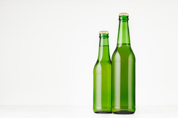 Group green longneck beer bottles 330ml, mock up. Template for advertising, design, branding identity on white wood table.