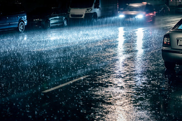 car in motion with switched on headlights driving during heavy rain - Powered by Adobe