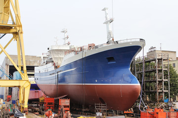 Big ship  on dry dock in shipyard.