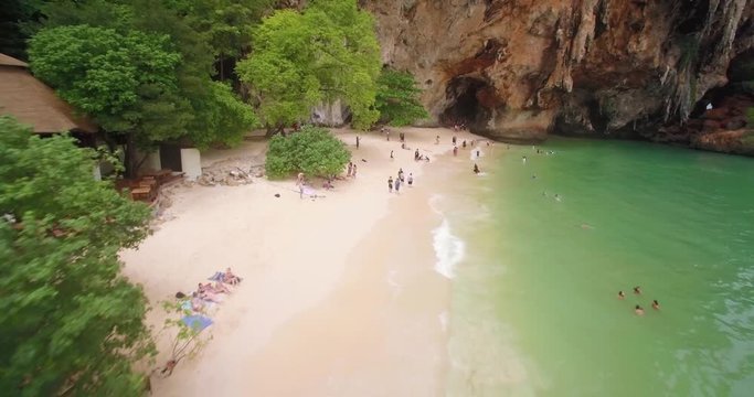 Tourists Near Princess Cave On Phra Nang Beach, Railay, Thailand, Aerial Pullback Shot
