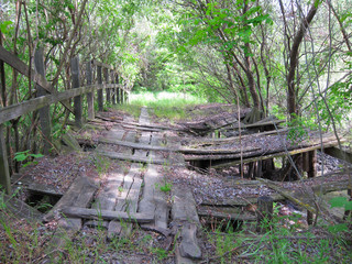 Very old damadged wooden hanging footbridge across river