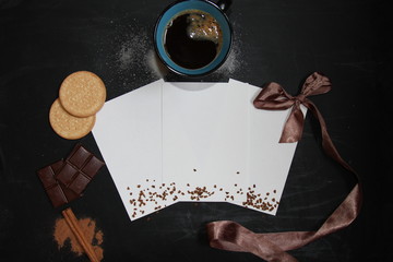 Coffee background with paper, cookies, cinnamon, cup of coffee, sugar and chocolate. Place for your text. Mockup.