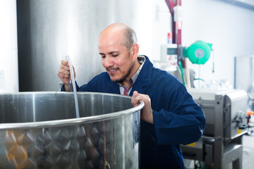 Fototapeta premium mature man working in wine fermentation section.