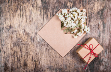 Dry white flowers in an envelope and a small box with a gift. Backgrounds and templates.