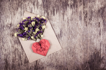Romantic letter. Wild flowers and a paper heart. Heart of origami.