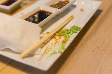 Empty dirty plate of sushi on table in cafe.