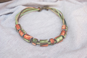 Autumn tube necklace. Handmade jewelry from polymer clay. Green orange beads. Fashion modern background.