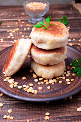 Roasted pea patty in brown plate on wooden background. Close up.