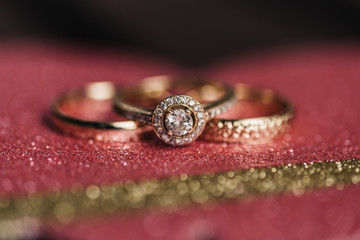 Close-up of wedding rings and engagement on a glittering background