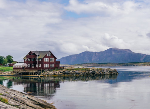 Red Wood Small House On The Stone Seascape With Background Of Sky With Clouds. By Letowa.