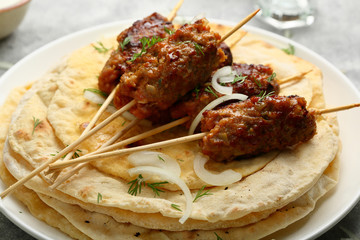 kebabs on skewers with flat breads