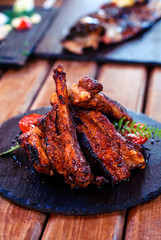 Pork ribs in a sauce served with herbs and vegetables.