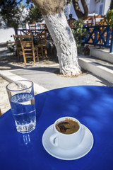 Cup of Greek coffee and water in traditional greek cafe.